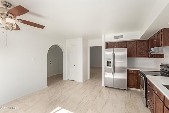 kitchen with decorative backsplash, dark brown cabinets, stainless steel appliances, and ceiling fan