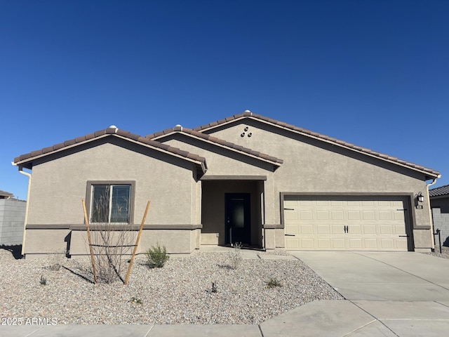 single story home featuring driveway, a tiled roof, an attached garage, and stucco siding