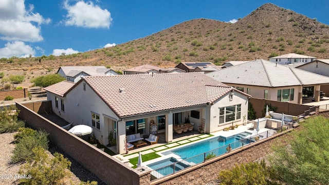 2037 E Fallen Leaf Ln, Phoenix, AZ 85024 - rear view of property featuring an outdoor hangout area, a pool with connected hot tub, a fenced backyard, and stucco siding