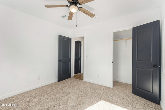 unfurnished bedroom featuring light colored carpet, ceiling fan, and a closet