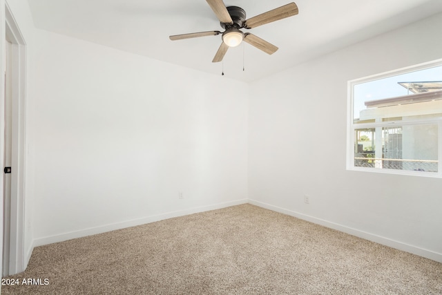 carpeted spare room with ceiling fan