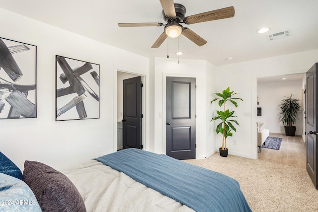 carpeted bedroom featuring ensuite bath and ceiling fan