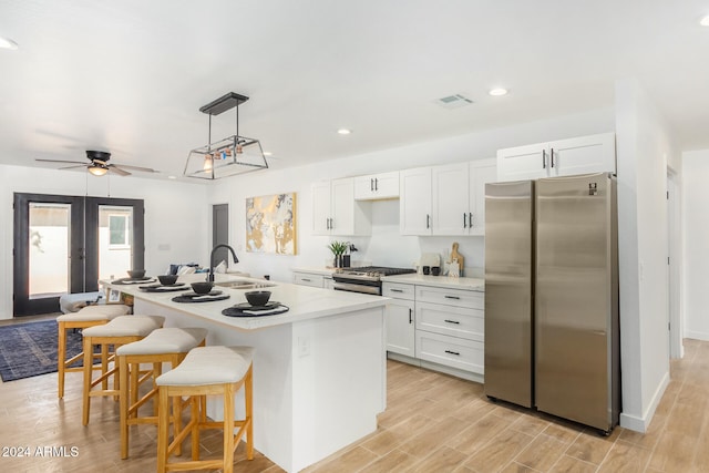 kitchen featuring white cabinetry, sink, an island with sink, and stainless steel appliances