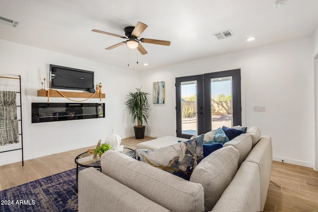 living room featuring french doors, light hardwood / wood-style floors, and ceiling fan