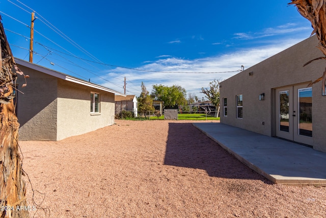 view of yard with french doors and a patio