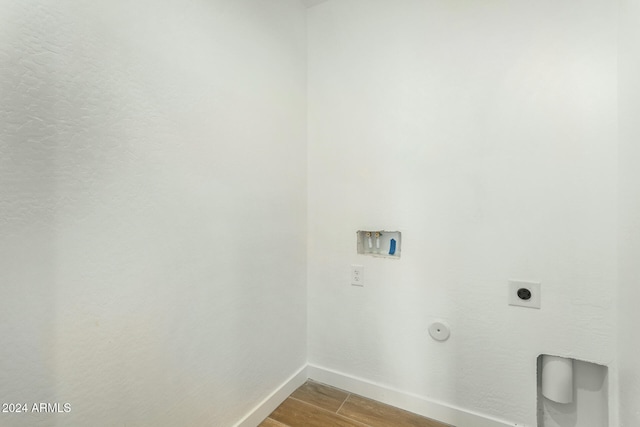 clothes washing area with hookup for a washing machine, electric dryer hookup, and hardwood / wood-style flooring