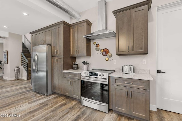 301 S O Leary St, Flagstaff, AZ 86001 - kitchen featuring baseboards, appliances with stainless steel finishes, wood finished floors, wall chimney range hood, and recessed lighting