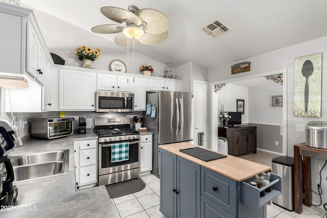 863 W 14th Ave, Apache Junction, AZ 85120 - kitchen featuring stainless steel appliances, white cabinets, light tile patterned floors, wooden counters, and vaulted ceiling