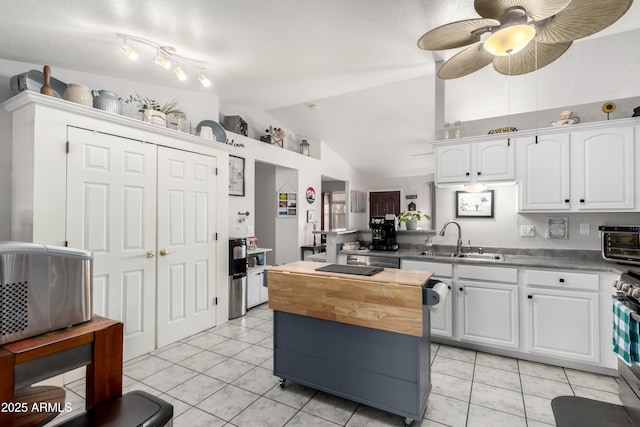 863 W 14th Ave, Apache Junction, AZ 85120 - kitchen with vaulted ceiling, white cabinetry, light tile patterned flooring, a ceiling fan, and a peninsula