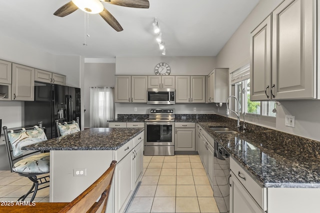 kitchen with gray cabinets, sink, a center island, light tile patterned floors, and black appliances