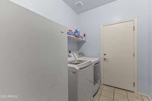 washroom with light tile patterned flooring and washer and clothes dryer