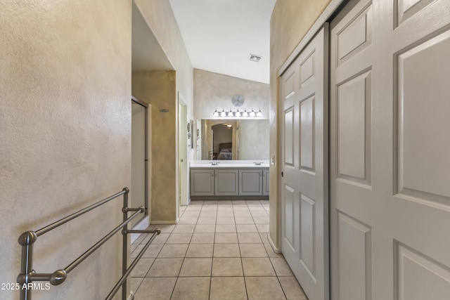 bathroom with tile patterned flooring, vanity, and walk in shower