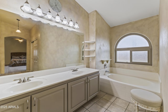 bathroom with vanity, a relaxing tiled tub, and tile patterned floors