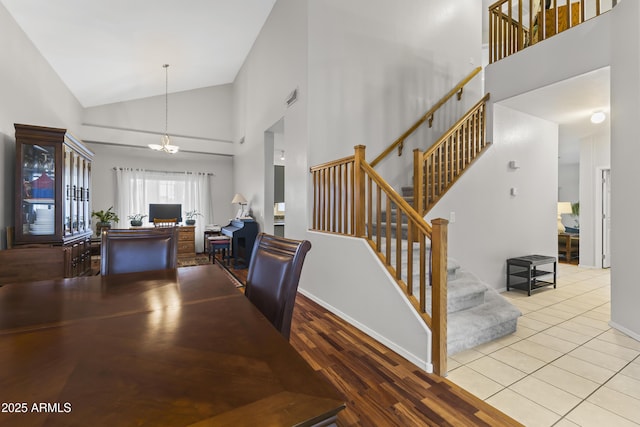 dining room featuring high vaulted ceiling, light hardwood / wood-style flooring, and a notable chandelier