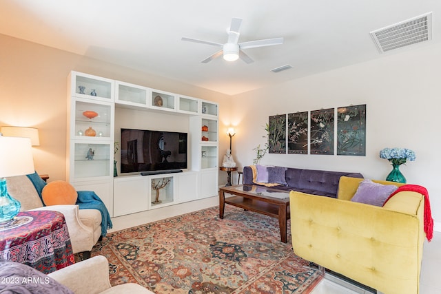 living room with built in shelves, tile patterned flooring, and ceiling fan