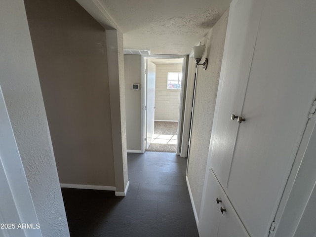 hallway with a textured ceiling