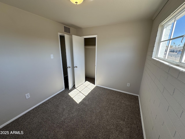 unfurnished bedroom with light colored carpet and a closet