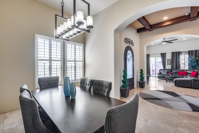 dining space with arched walkways, coffered ceiling, ceiling fan with notable chandelier, and beamed ceiling