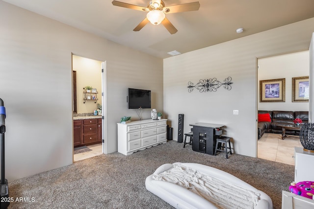 bedroom with ceiling fan, light carpet, ensuite bathroom, vaulted ceiling, and visible vents