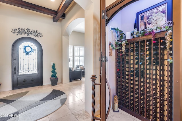tiled entrance foyer with arched walkways and beamed ceiling