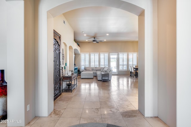 corridor featuring arched walkways, recessed lighting, and visible vents