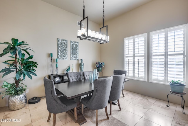 dining space featuring light tile patterned floors and a chandelier