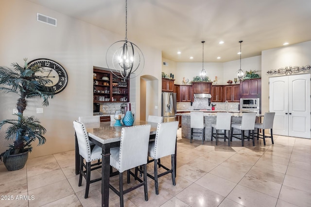 dining space with visible vents, recessed lighting, light tile patterned floors, and a chandelier