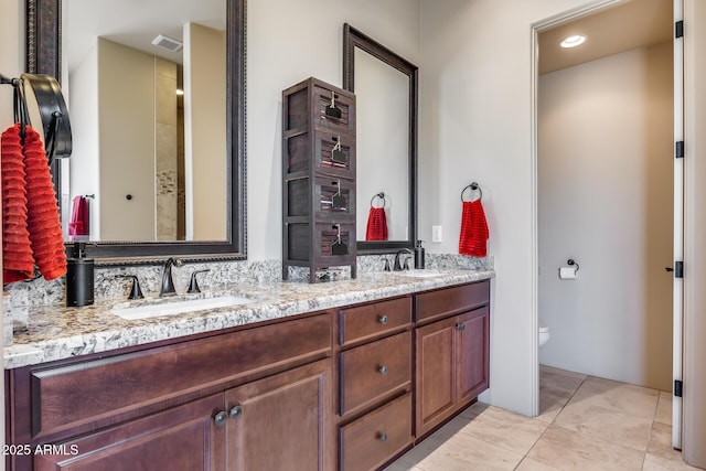 full bathroom with double vanity, a sink, visible vents, and toilet