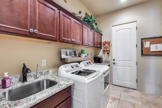 washroom with a sink, washing machine and dryer, and cabinet space
