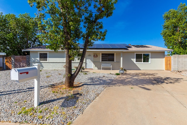 ranch-style house with solar panels