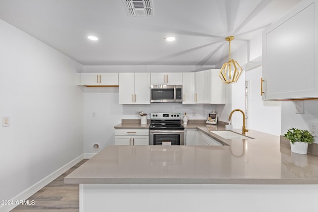 kitchen with light hardwood / wood-style floors, appliances with stainless steel finishes, kitchen peninsula, and sink