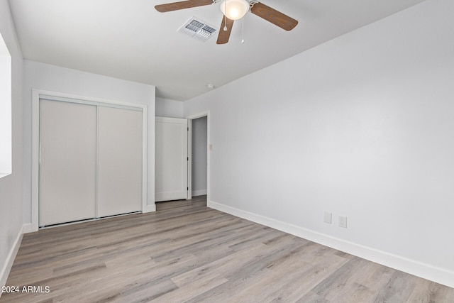 unfurnished bedroom with a closet, light hardwood / wood-style flooring, and ceiling fan