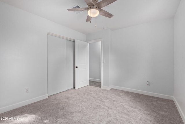 unfurnished bedroom with a closet, ceiling fan, and carpet flooring