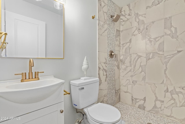 bathroom with vanity, toilet, and a tile shower