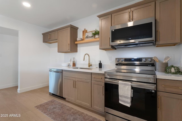 1205 W 7th St, Tempe, AZ 85281 - kitchen featuring stainless steel appliances, a sink, light wood-style flooring, and light countertops