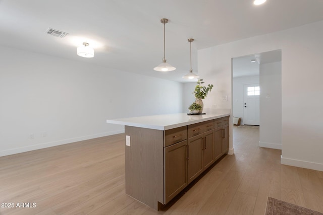 1205 W 7th St, Tempe, AZ 85281 - kitchen featuring light wood finished floors, light countertops, baseboards, and hanging light fixtures
