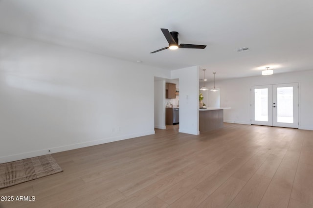 1205 W 7th St, Tempe, AZ 85281 - unfurnished living room featuring a ceiling fan, light wood-style flooring, french doors, and baseboards
