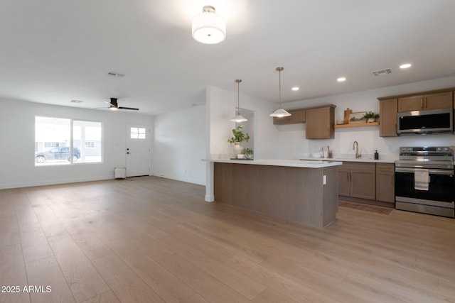 1205 W 7th St, Tempe, AZ 85281 - kitchen with stainless steel appliances, light wood finished floors, light countertops, open floor plan, and recessed lighting