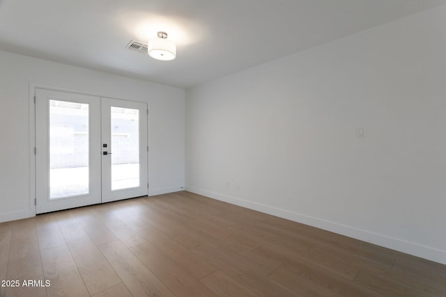 1205 W 7th St, Tempe, AZ 85281 - spare room featuring french doors, light wood finished floors, and baseboards