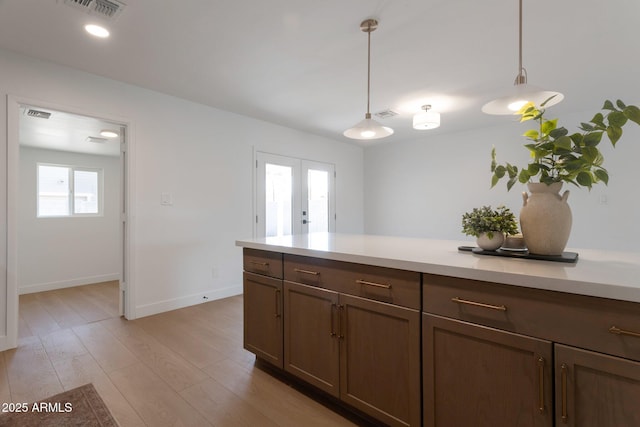 1205 W 7th St, Tempe, AZ 85281 - kitchen featuring light countertops, decorative light fixtures, light wood-type flooring, and baseboards