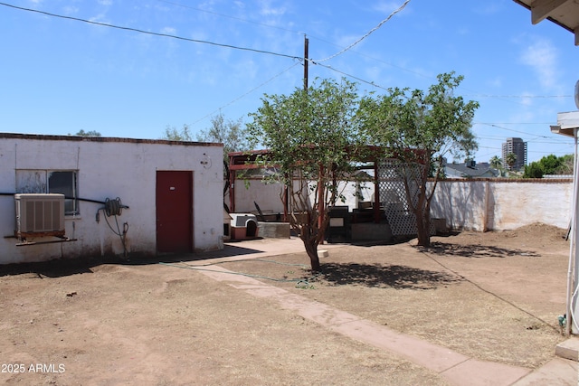 exterior space with central air condition unit and fence