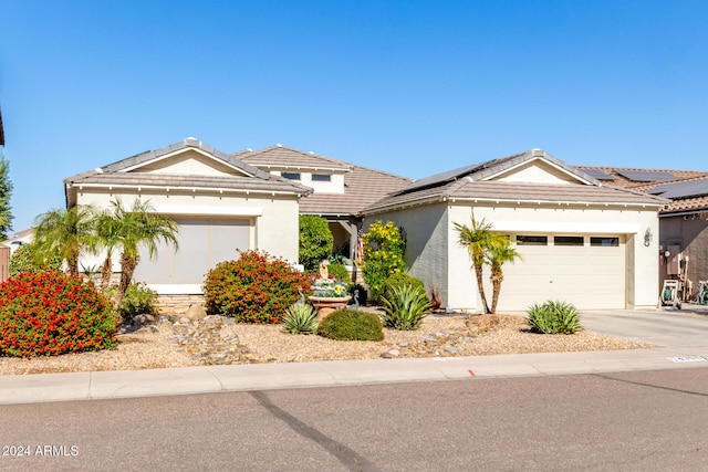 view of front of home featuring solar panels and a garage