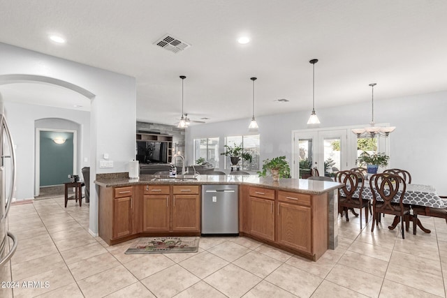 kitchen with ceiling fan, sink, stainless steel dishwasher, decorative light fixtures, and stone countertops