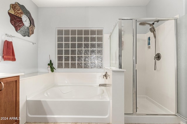 bathroom featuring plus walk in shower and vanity