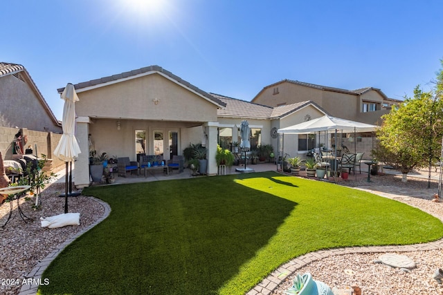 rear view of property featuring an outdoor hangout area, a patio area, and a lawn