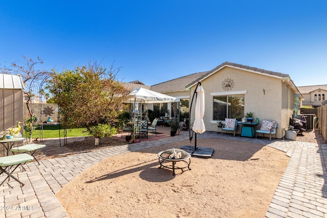 back of house with a patio and a fire pit