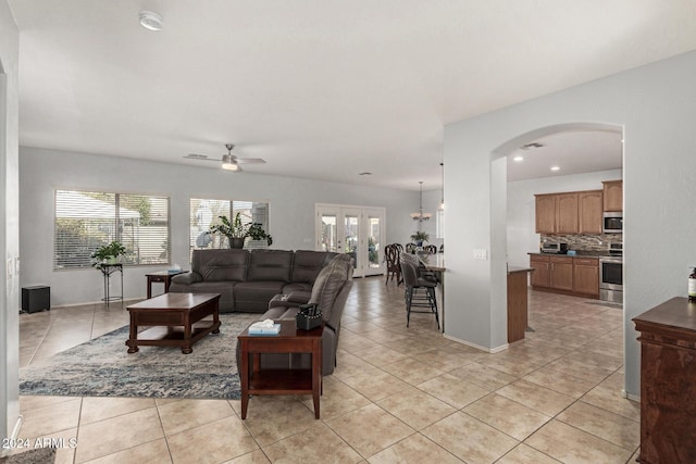 living room with ceiling fan, a healthy amount of sunlight, light tile patterned floors, and french doors