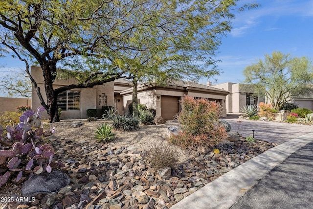 view of front of house featuring a garage, driveway, and stucco siding