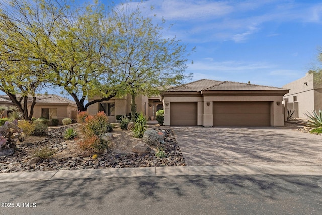 view of front of home featuring a garage, driveway, a tiled roof, and stucco siding