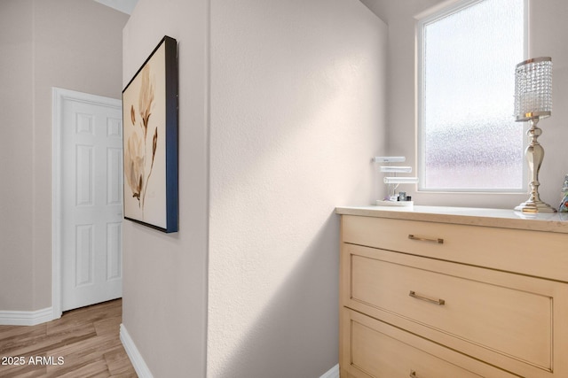 interior space featuring light wood-type flooring and baseboards